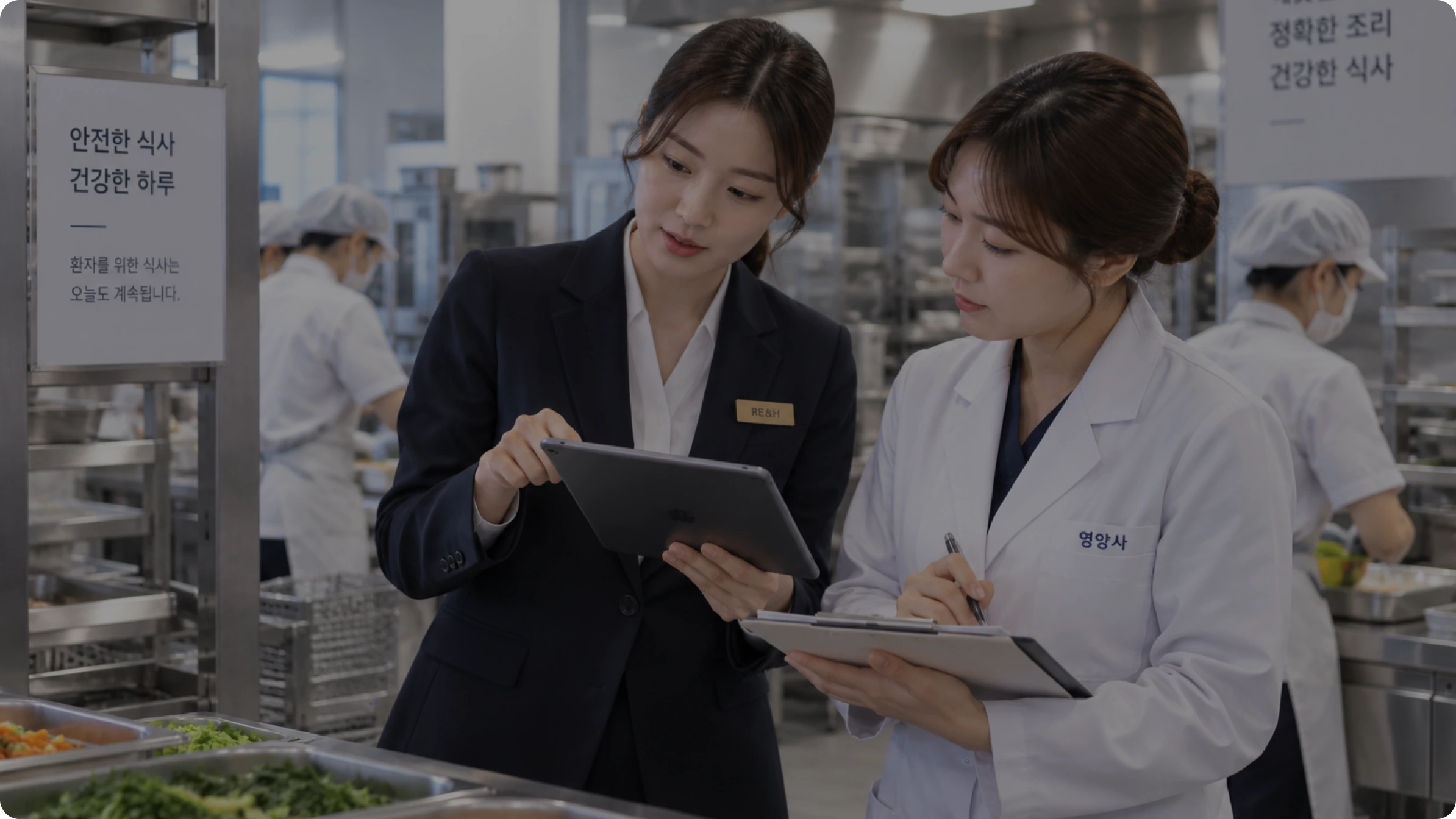 병원 조리 현장에서 RE&H 담당자와 영양사가 운영 점검표를 함께 확인하는 모습